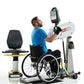 Man in wheelchair using white SCIFIT PRO1 upper body exercise machine with digital display, wearing blue shirt on white backg