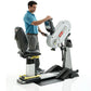 Man in blue polo shirt using white and black upper body exercise machine with digital console display on white background