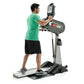 Male model in green t-shirt using gray and black SCIFIT PRO1 upper body exerciser with digital display, shown in side profile