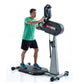 Man in green shirt and black shorts using standing upper body ergometer with black and gray frame on white background