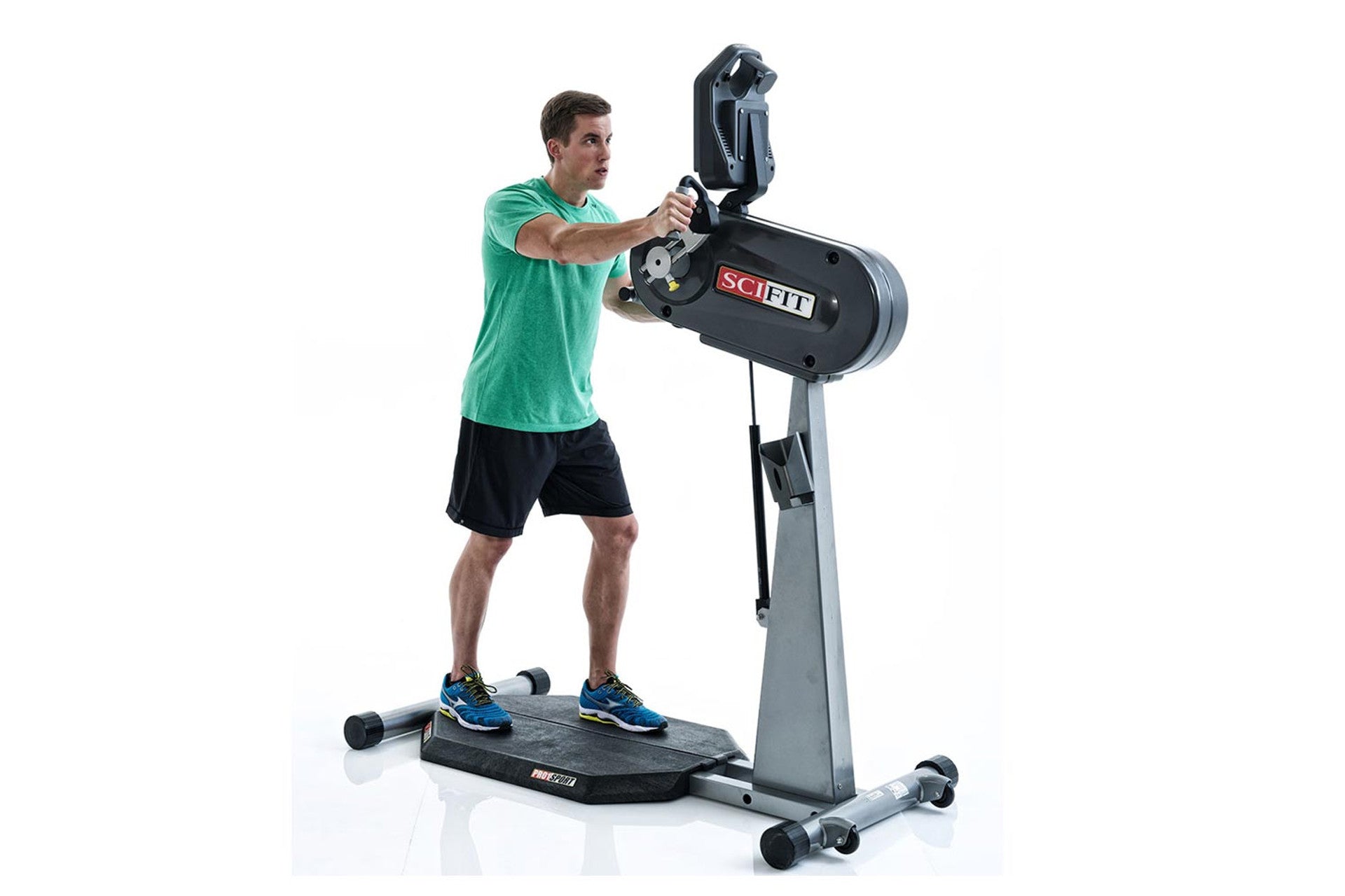 Man in green shirt and black shorts using standing upper body ergometer with black and gray frame on white background