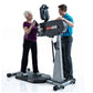 SCIFIT PRO1 Sport standing upper body ergometer with gray frame and black cylindrical resistance unit, demonstrated by two us