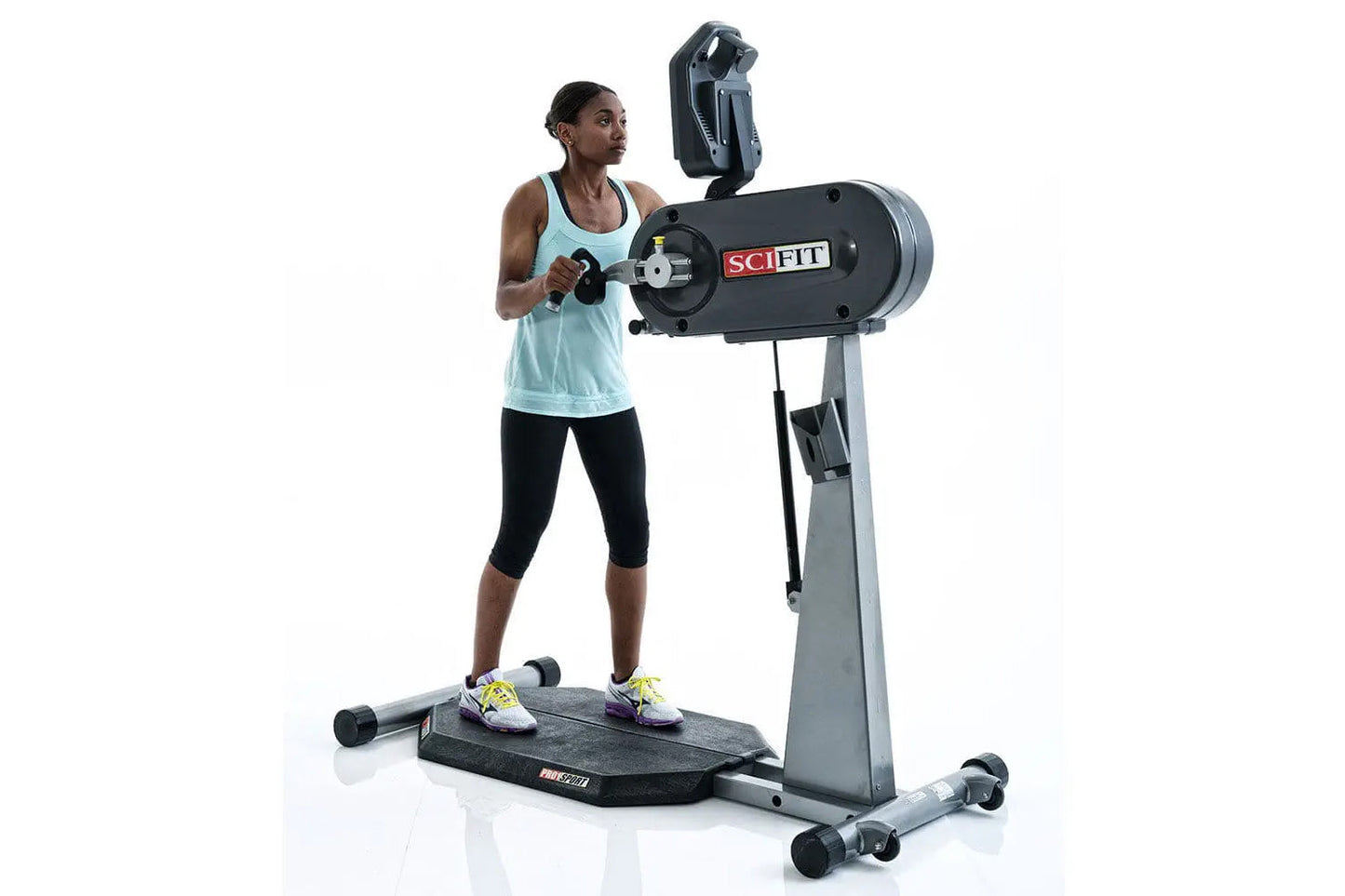 Woman in light blue tank top using black and gray SCIFIT PRO1 standing upper body ergometer with smartphone holder, on white 