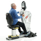 Older man in blue shirt using white and black SCIFIT upper body exercise machine with digital display monitor, seated positio