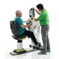 Older man in teal shirt seated on white and black exercise machine with trainer in green shirt adjusting digital monitor abov