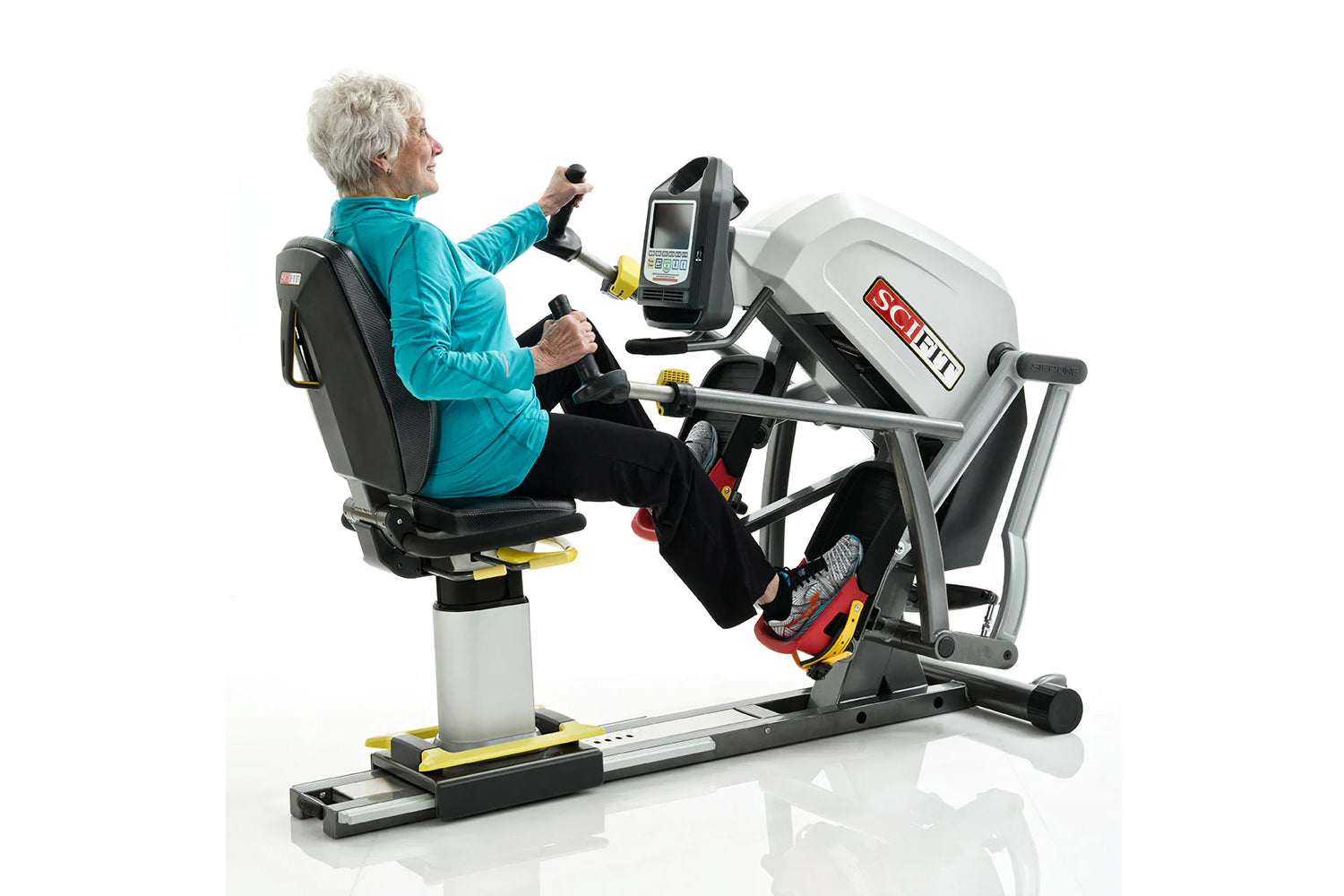 Older adult using SCIFIT StepOne recumbent stepper with white and gray frame, holding handles while exercising, white backgro