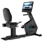 Black recumbent exercise bike with blue accent lighting, digital touchscreen display, padded seat, and foot pedals on white b