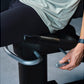 Man wearing black pants and light green shirt using Life Fitness Symbio recumbent cycle with blue handles, shown in close-up 