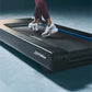 Person wearing burgundy leggings and white mesh sneakers running on Life Fitness black treadmill with blue accents
