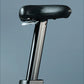 Stationary bike seat with black padded top, metal post with height adjustment markings, and gray background