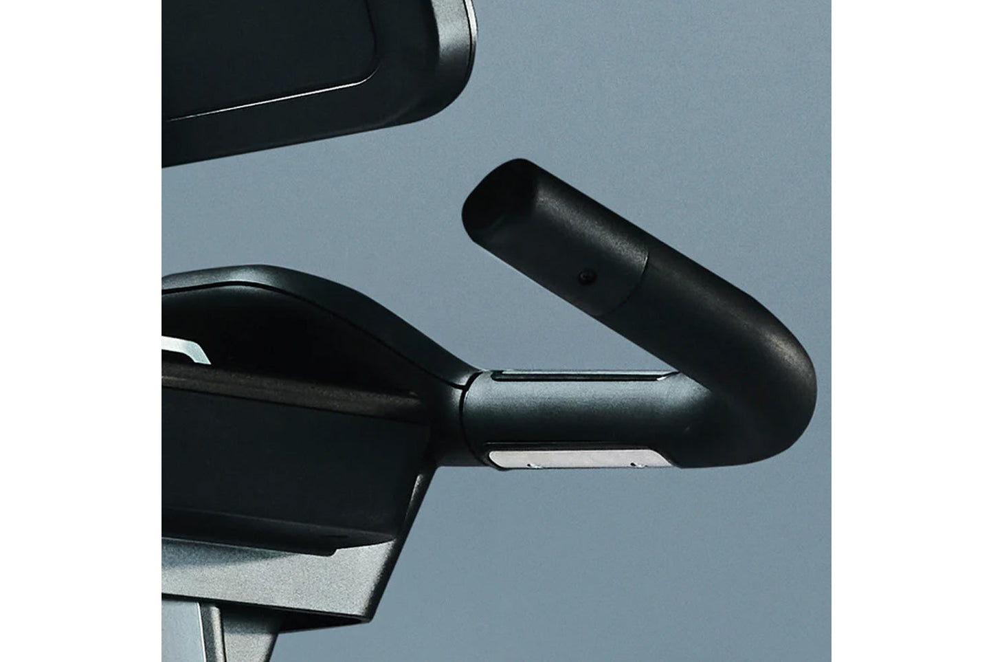 Black and silver exercise bike handlebar with ergonomic grip on blue background