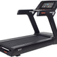 Black commercial treadmill with touch screen console, orange accent trim, and cushioned running deck on white background