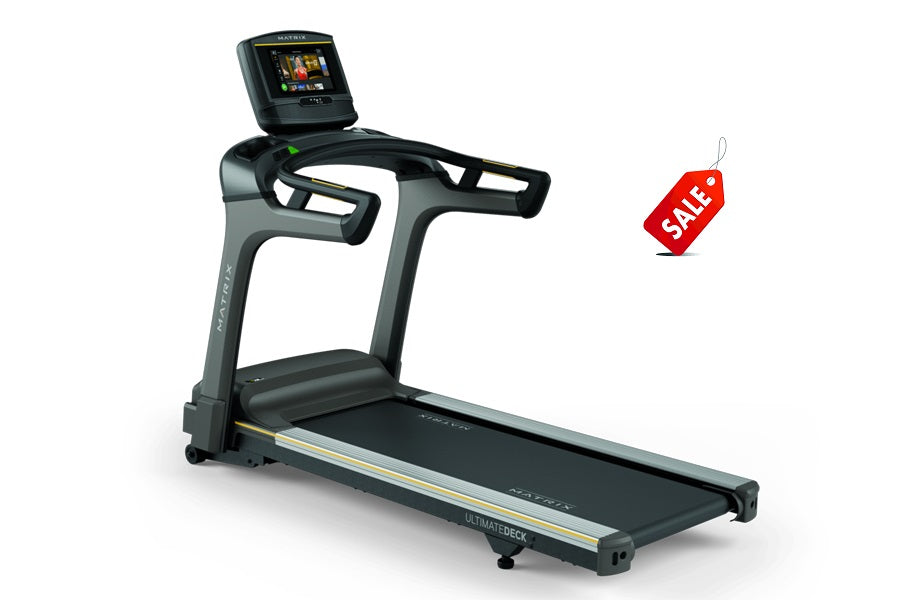 Matrix T75 treadmill with black running belt, gray frame, digital display console, and integrated handrails, shown on white b