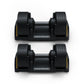 Pair of black Matrix adjustable dumbbells with yellow accents and textured grip handles, displayed on white background