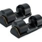 Pair of black Matrix adjustable dumbbells with gold accents on bases, shown on white background