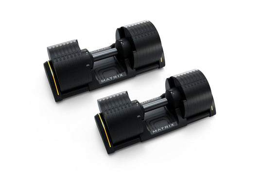 Pair of Matrix adjustable dumbbells with black rubber grip plates, steel handles, and yellow accents on base, shown on white 