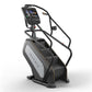 Matrix Endurance ClimbMill with black frame, gray and white base, digital display console, and dual black handrails on white 