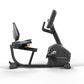 Matrix Endurance recumbent exercise bike with black frame, padded seat, digital display console, and adjustable handlebar on 