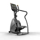 Matrix Endurance Stepper with digital display, black handles, gray base, and foot pedals on white background