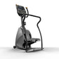 Matrix Endurance Stepper with digital display, black frame and handles, gray base, and dual foot pedals on white background