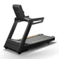 Black Matrix commercial treadmill with digital console, gray running deck with yellow stripe, and handrails on white backgrou