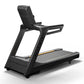 Matrix black commercial treadmill with digital display console, gray running deck, and cushioned handrails on white backgroun