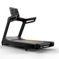 Black commercial treadmill with digital display console, handrails, and gray running deck with orange accent stripe on white 