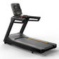 Black commercial treadmill with digital display console, yellow accent stripe, and wide running belt on white background