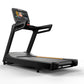 Black Matrix treadmill with digital touchscreen display, handrails, and orange accent stripe on running belt, on white backgr