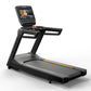 Black Matrix commercial treadmill with digital touchscreen display showing workout interface, wide running deck, and orange a
