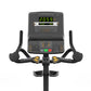 Matrix Endurance Upright Cycle with digital console, black frame, curved handlebars with gold accents, and foot pedals on whi
