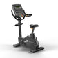 Matrix Endurance upright stationary exercise bike with digital display console, black frame, and padded seat on white backgro