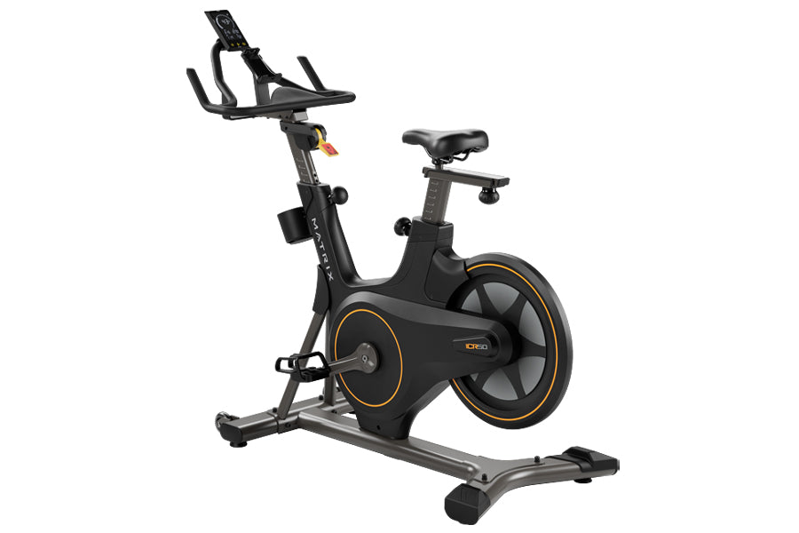 Black and gray stationary indoor exercise bike with orange accents, adjustable seat, handlebar console, and large flywheel on