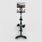 Black stationary indoor exercise bike with tablet mount displaying road landscape, viewed from front on white background