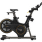 Black and gold Matrix ICR50 indoor cycling bike with adjustable handlebars and seat, viewed from the side on white background