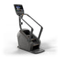 Black and gray commercial climbing machine with digital touchscreen display and handrails on white background