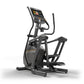 Black elliptical machine with digital console displaying fitness metrics, gold accents, and dual handles on white background
