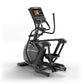 Black and gold elliptical trainer with digital display console, dual handles, and foot pedals on white background