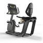 Matrix Lifestyle black recumbent exercise bike with digital display console, seat, and backrest on white background