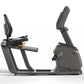 Matrix Lifestyle recumbent stationary bike with gray frame, padded seat, horizontal pedals, and digital console on white back
