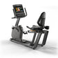 Black and gray Matrix recumbent exercise bike with digital display screen and padded seat, shown on white background