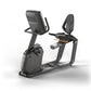 Matrix black recumbent exercise bike with digital display, orange resistance handle, and padded seat on white background