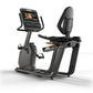 Matrix Lifestyle recumbent exercise bike with black frame, digital display console, and padded backrest on white background