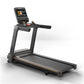 Black Matrix treadmill with orange accents, touchscreen display console, and dual handles on white background