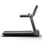 Matrix Lifestyle treadmill with black frame, gray upholstered seat, and digital console on white background