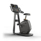 Black upright stationary exercise bike with digital display console, handlebars, padded seat, and metal frame on white backgr