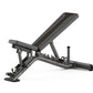 Matrix multi-adjustable weight bench in charcoal gray with gold accent lines, adjustable backrest, and weighted leg extension