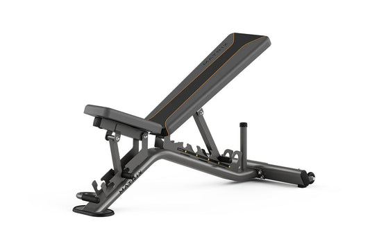 Matrix multi-adjustable weight bench in charcoal gray with gold accent lines, adjustable backrest, and weighted leg extension