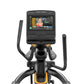 Black and gold Matrix elliptical trainer with dual handles, foot pedals, and touchscreen display showing workout interface on