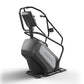 Matrix Performance ClimbMill with black and gray frame, handrails, and digital console on white background